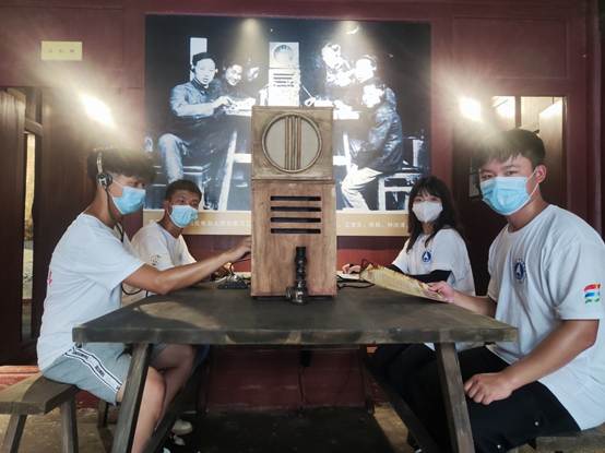 说明: F:\8 伟德BETVLCTOR\4 办公室工作\大创、挑战杯、社会实践\伟德BETVLCTOR+移动博物馆赋能党史学习教育+实践团\三下乡--铭记革命历史,传承红色文化,推进党史学习\实践团成员在讲解员的指导下体验电报机.jpg